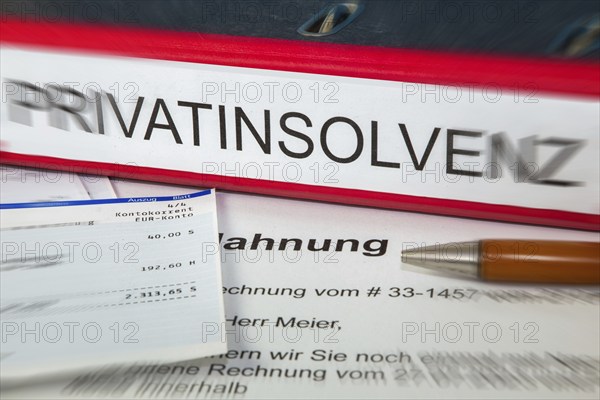 Symbolic image of personal insolvency: folder, bank statement and a reminder