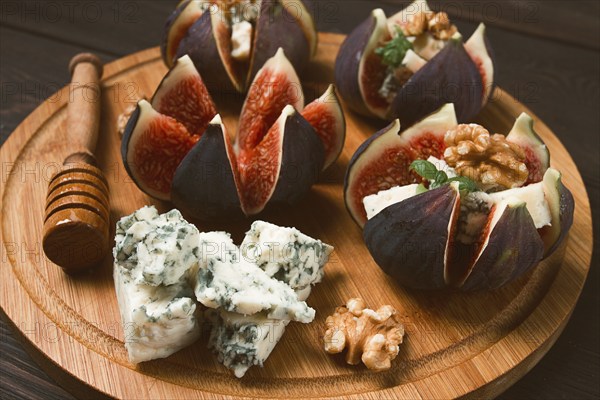 Appetizer, Figs with blue cheese, walnut, honey, on a wooden board, top view, close-up, no people