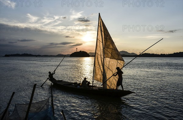 Fishermen paddle down the Brahmaputra River after fish in Guwahati, Assam, India on August 25, 2019