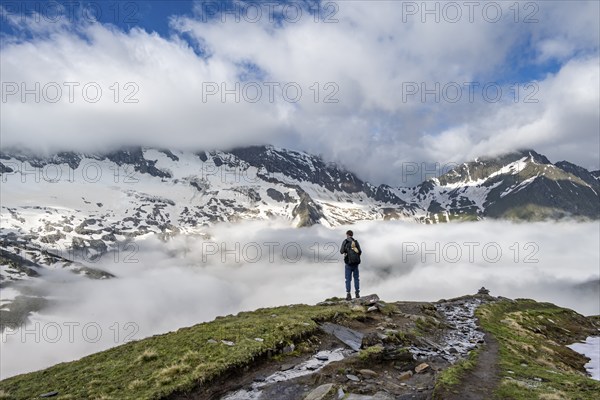 Mountaineer in front of mountain landscape with high fog in the valley, summit Hochfeiler and