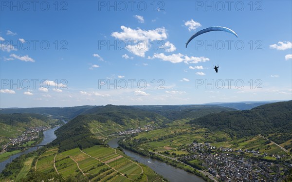 Paraglider flies high above the river with a wide view over the landscape, Paragliding, Bremm,