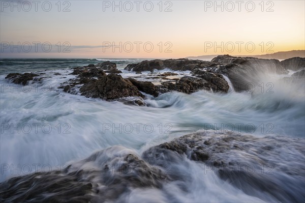 Waves washing over rocks by the sea, long exposure, coastal landscape at sunset, Playa Cocalito,