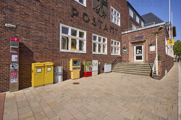 Entrance to the post office with public telephone, letterboxes and stamp vending machine in Bad