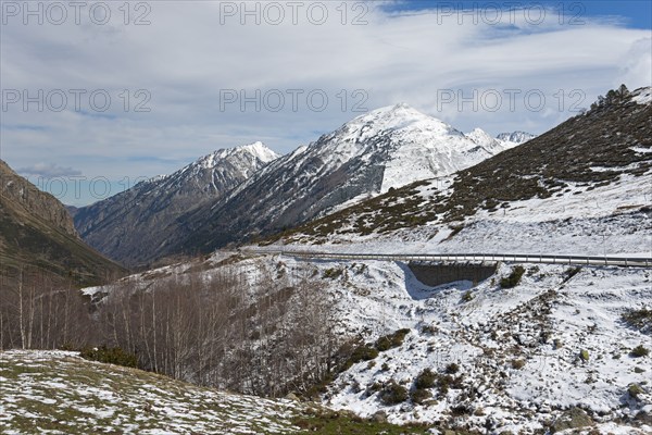Berglandschaft mit Resten von Schnee am Straßenrand und bewölktem Himmel, nördlich von El Pas de la
