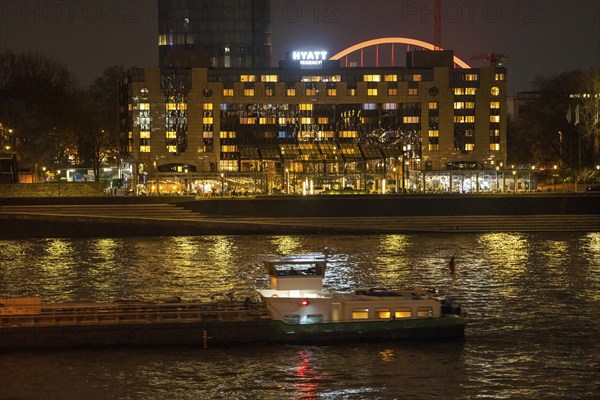 The Hyatt Regency Hotel on the Rhine, in Cologne Deutz, behind it the illuminated arch of the