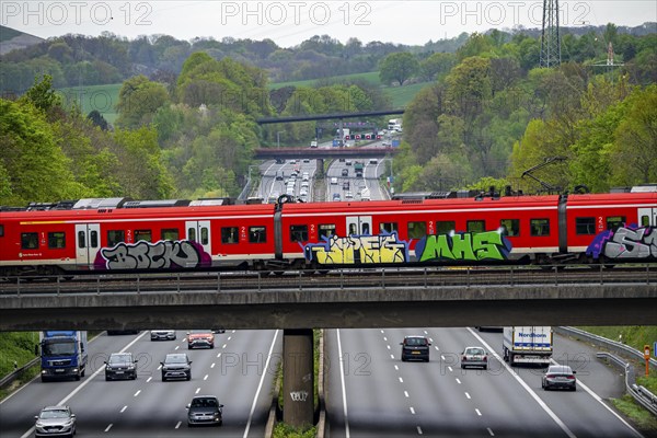 S-Bahn train crossing the motorway A3, traffic on 8 lanes, incl. the temporarily released hard