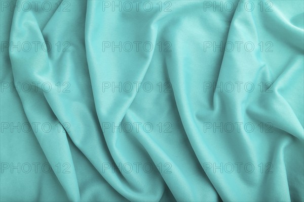 Fragment of silk blue tissue. Top view, natural textile background and texture. wave concept,