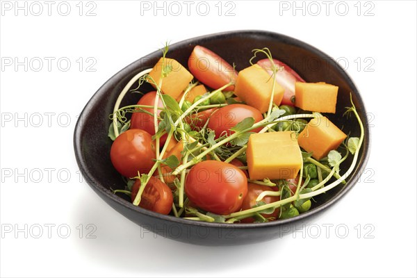 Vegetarian vegetable salad of tomatoes, pumpkin, microgreen pea sprouts isolated on white