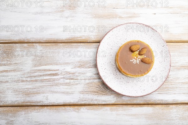 Sweet tartlets with almonds and caramel cream on a white wooden background. top view, flat lay,