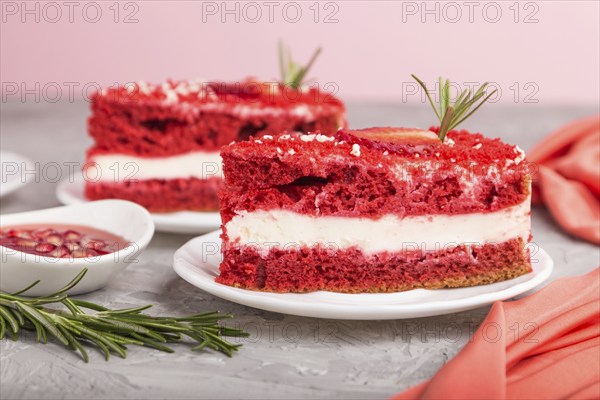 Homemade red velvet cake with milk cream and strawberry on a gray concrete background with red