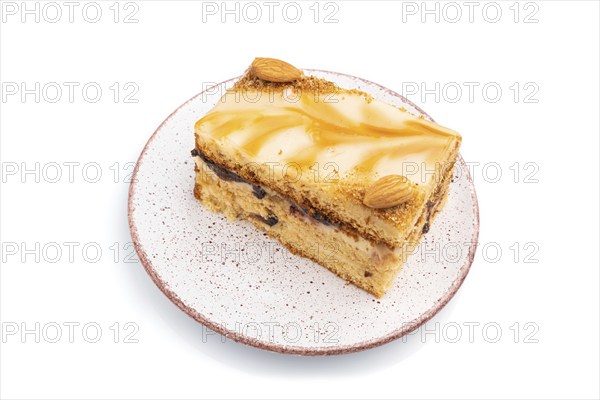 Honey cake with milk cream, caramel, almonds isolated on a white background. Side view, close up
