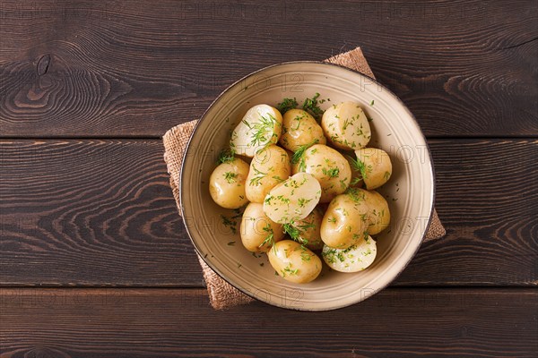 Fresh Cooked, new potatoes, with dill, on a wooden table, selective focus. close-up, toning, no