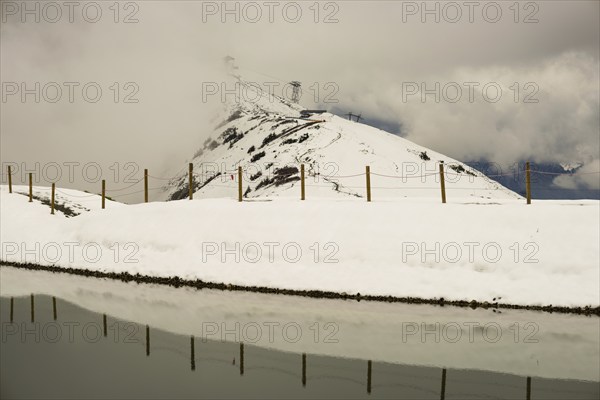 After snowfall in May: Riezler Alpsee, an artificial lake, snow pond, feeds the snow cannons that