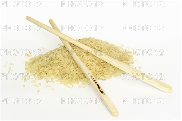 Rice (Oryza sativa), rice grains and chopsticks on a white background