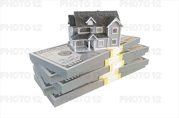 Miniature house resting on stack of thousands of dollars cash isolated on a white background