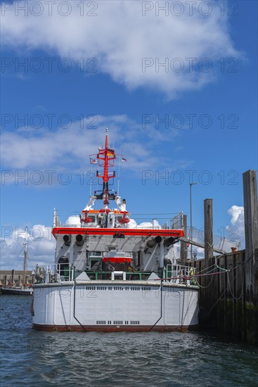 DGzRS rescue cruiser Hermann Marwede with dinghy in the harbour, stern view, Helgoland island, blue