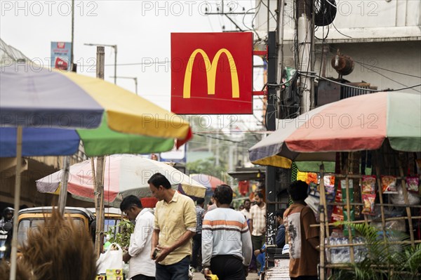 People walks by a McDonald's sign on October 26, 2024 in Guwahati, India. McDonald's recent food