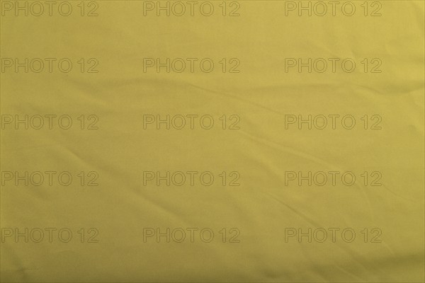 Fragment of smooth green olive silk tissue. Top view, flat lay, natural textile background and