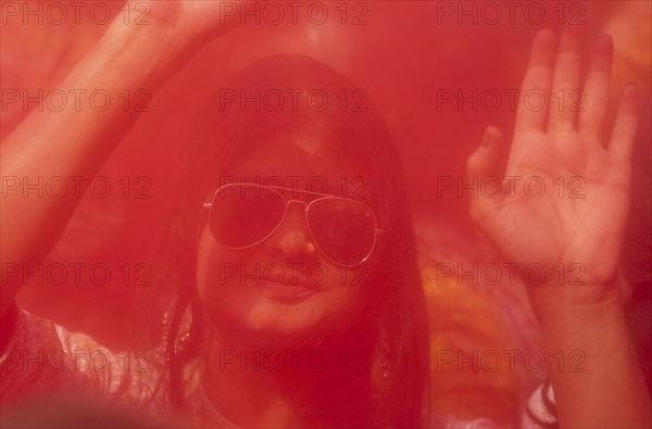A girl dancing in the beat of music as she celebrate Holi on a street, the Hindu spring festival of