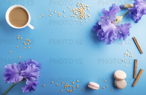 Purple iris flowers and a cup of coffee on a blue pastel background. Morninig, spring, fashion