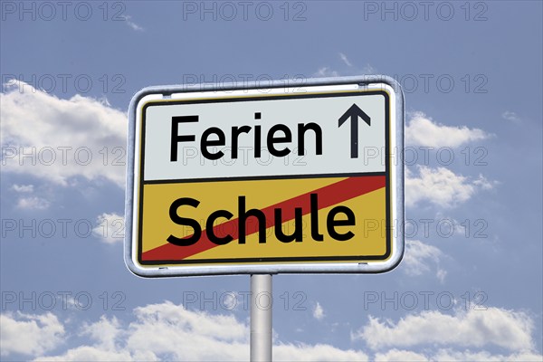 Symbolic image: German town exit sign with the words Schule/Ferien against a blue sky