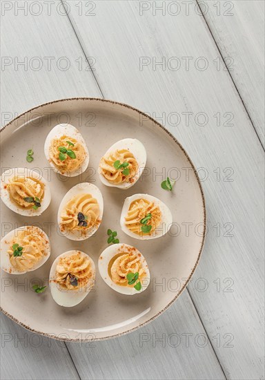 Boiled eggs stuffed with yolk with mayonnaise, on a white plate, selective focus, blurry, close-up,