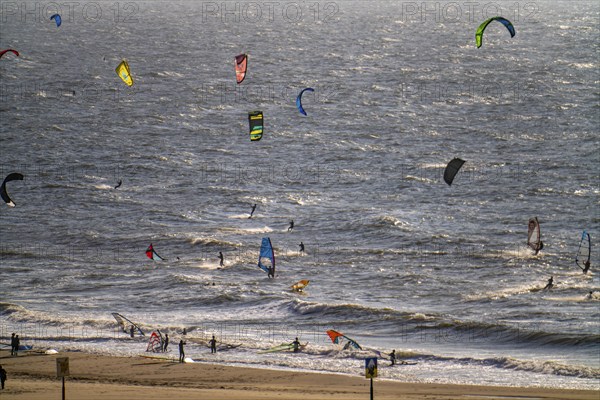 Kitesurfers and windsurfers in strong winds on the beach of Scheveningen, The Hague, Netherlands