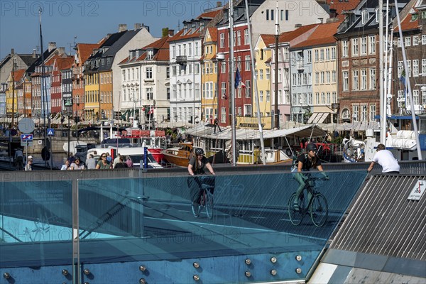 Cyclists on the Inderhavnsbroen cycle and footpath bridge, over the harbour, at Nyhavn, Copenhagen