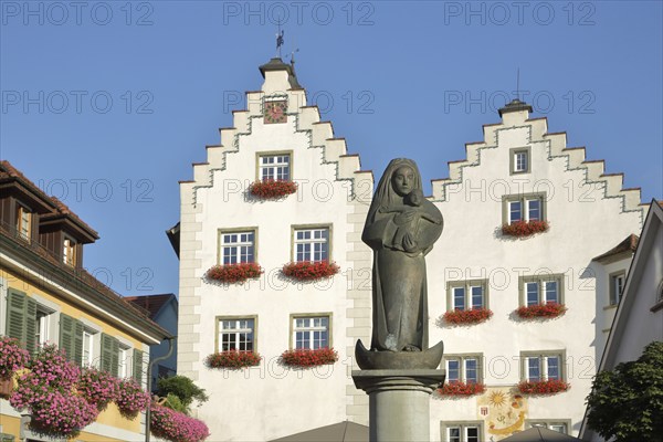 Madonna figure at the fountain and historic gate castle with stepped gable, town gate, town tower,
