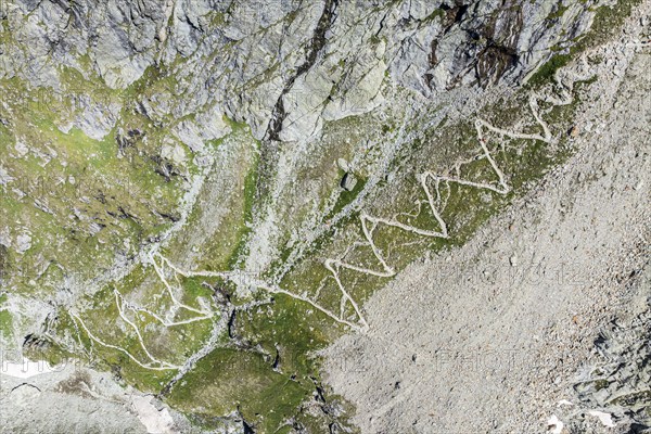 Serpentines of hiking trail up to mountain hut Cabane de Moiry, aerial view, Valais, Switzerland,