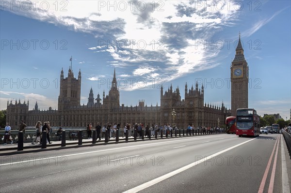 Big Ben and Palace of Westminster behind a bridge with buses and tourists, London, United Kingdom,