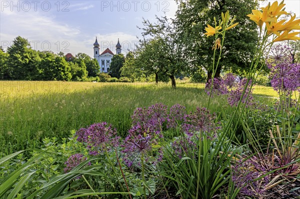 Colourful flowers in front of the church towers of a monastery against the light, spring, sunny,