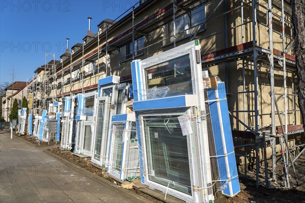 Energy-efficient refurbishment of residential buildings, older apartment block is scaffolded, gets