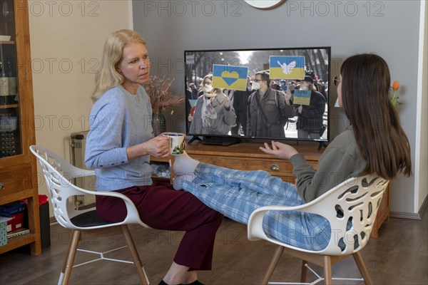 Mother and daughter, teenage, 13 years old, in a confidential conversation, at home, talking about