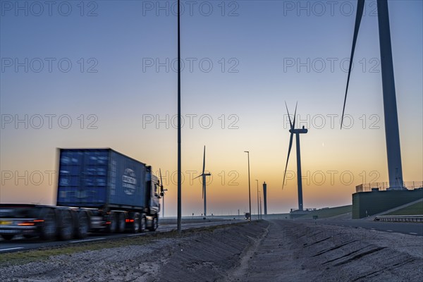 Lorry on the road from Euromax Terminal Rotterdam, ENECO wind farm on the dike around the port of