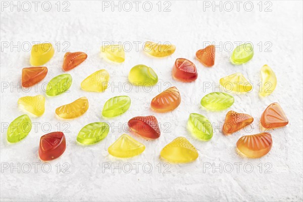 Various fruit jelly candies on gray concrete background. side view, close up