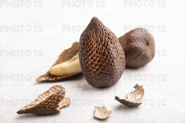 Salak or snake fruit on gray concrete background. Side view, close up, selective focus. Tropical,