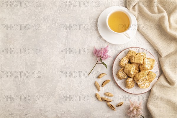 Traditional turkish delight (rahat lokum) with cup of green tea on a gray concrete background and