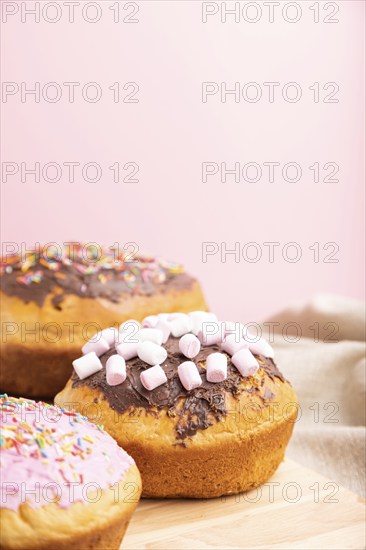 Homemade glazed and decorated easter pies with chocolate eggs and rabbits on a gray and pink