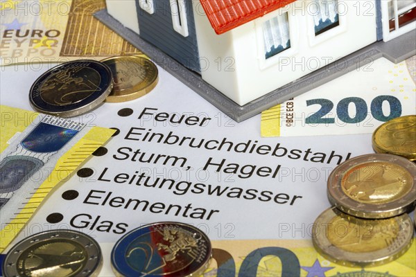 Symbolic image of building insurance: close-up of contract documents, a model house, euro banknotes