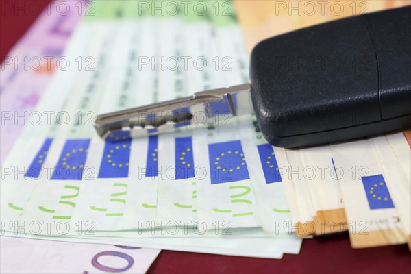 Euro banknotes and car keys as a symbol for car costs