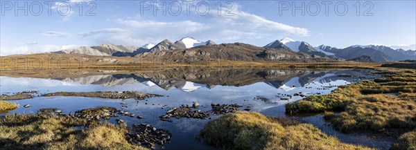 Glaciated mountain peaks reflected in a mountain lake at sunset, Arabel Lake at Arabel Pass, Issyk
