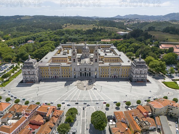 Aerial view of a historic palace in baroque style, surrounded by green vegetation and old building
