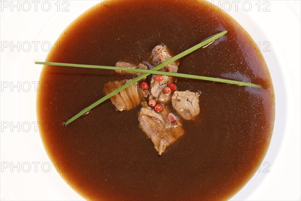 Southern German cuisine, oxtail soup with red pepper in a soup plate, bound soup, meat soup,