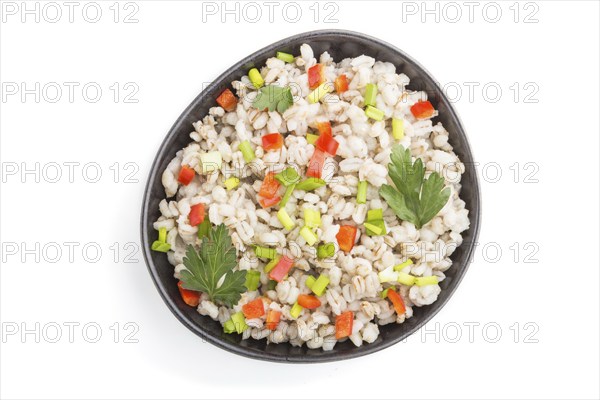 Pearl barley porridge with vegetables in blue ceramic bowl isolated on white background. Top view,