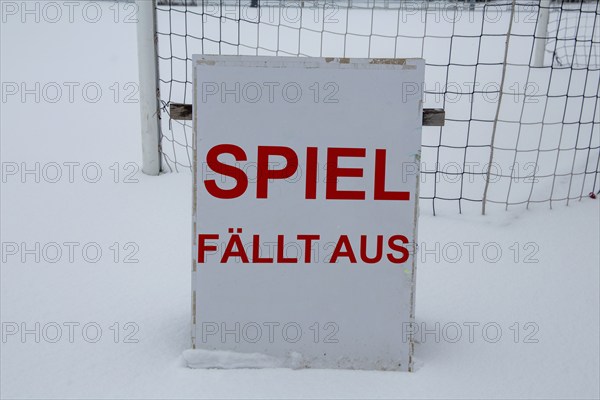 Symbolic image of a football match cancelled due to snow. Sign on a sports field with the
