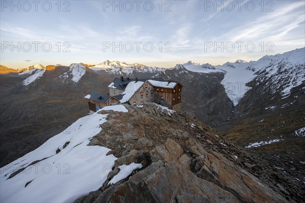 Snow-covered mountain landscape, mountain hut Ramolhaus in autumn with snow, at sunset, view of
