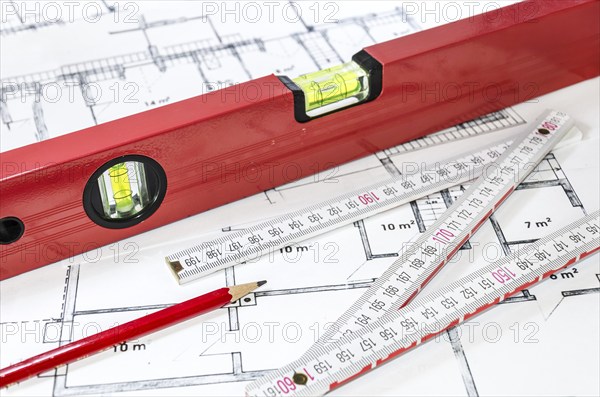 Spirit level, pencil and yardstick on a construction plan