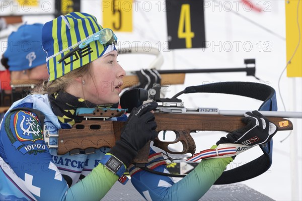 Russian sportswoman biathlete Legostaeva Anastasia rifle shooting in prone position. Biathlete in