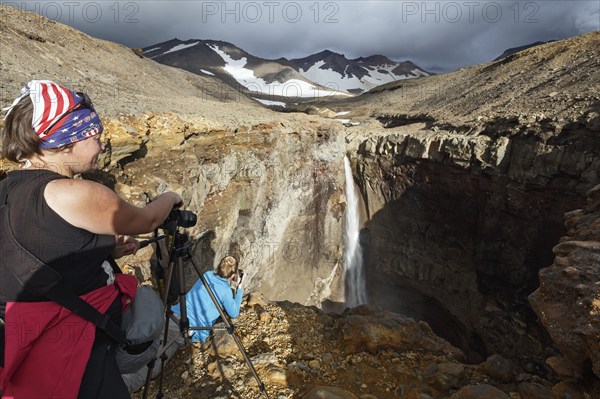 MUTNOVSKY VOLCANO, KAMCHATKA PENINSULA, RUSSIA, SEP 8, 2015: Young women tourists photographers